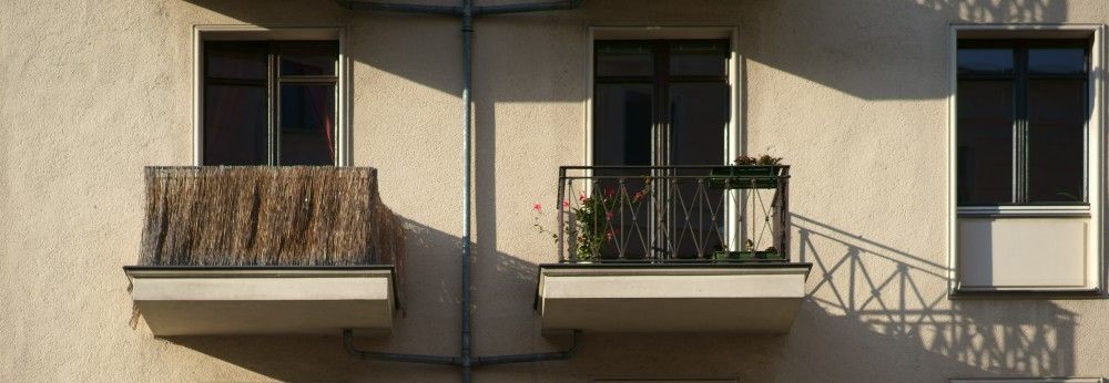 Mehrere kleine Balkone mit unterschiedlichen Sichtschutzvorrichtungen.